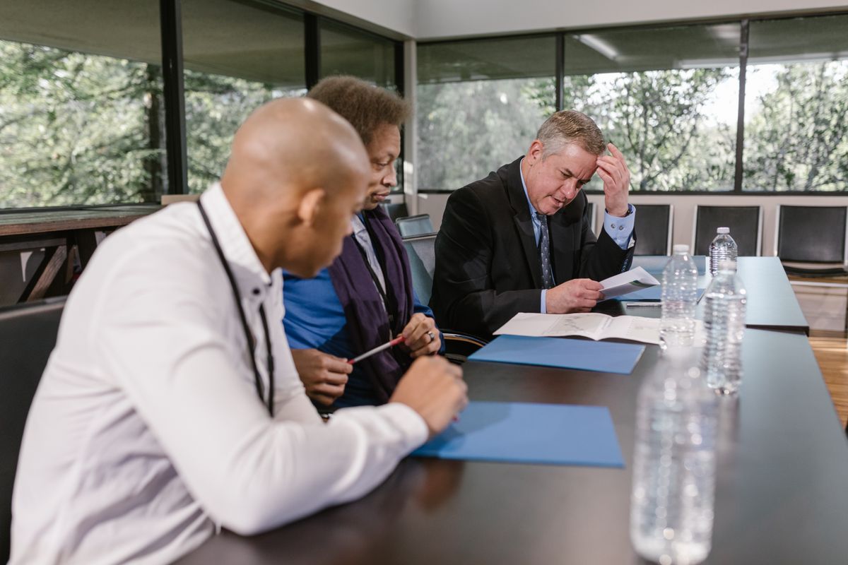 Formal business meeting reviewing documents about guaranteed rent company risk
