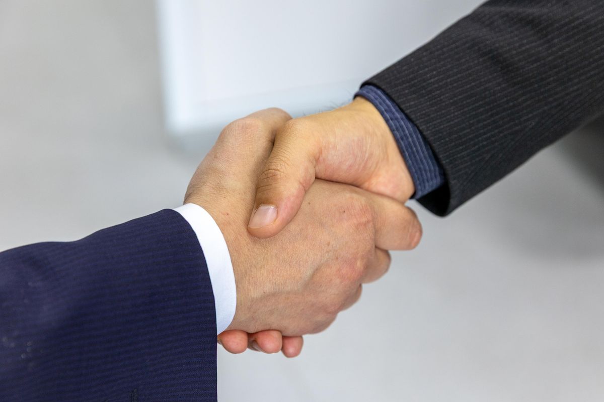 Corporate handshake representing a corporate let sitting outside the AST regime