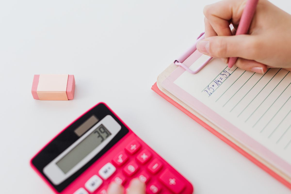 Running the numbers on a calculator and notepad to compare Airbnb income with guaranteed rent