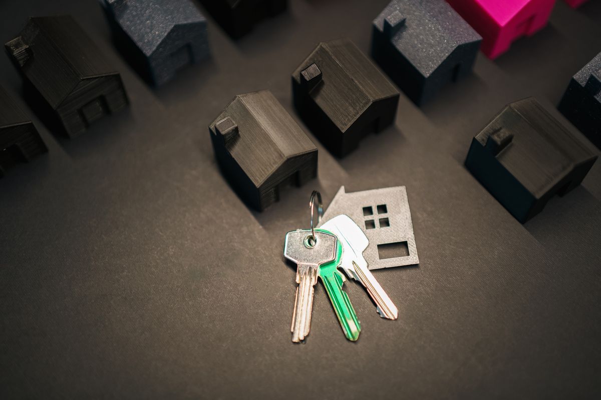 House keys and model houses representing a switch from letting agent to guaranteed rent