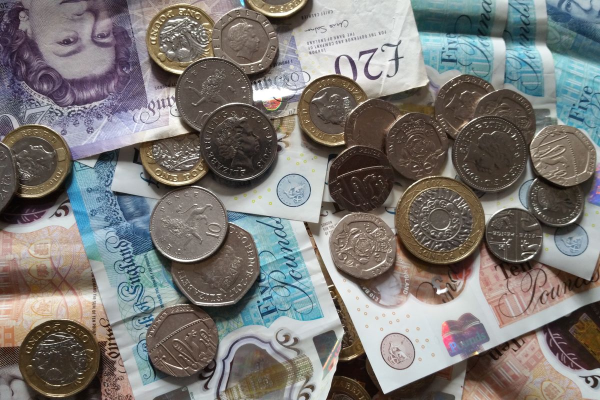 British pound coins and notes representing guaranteed rent income in Manchester